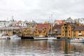 Haugesund, Norway - January 9, 2018: Old wooden houses on the island Risoy, boats and fishing industry buildings. Sild