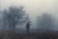 A haunted figure on a path on a hill on a moody, foggy winters day. With an abstract, grain, grunge edit Royalty Free Stock Photo