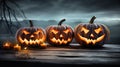 Haunted Harvest Trio Three Spooky Halloween Pumpkins with Evil Faces on Wooden Bench, Table, and Misty Gray Coastal Night Royalty Free Stock Photo