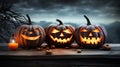 Haunted Harvest Trio Three Spooky Halloween Pumpkins with Evil Faces on Wooden Bench, Table, and Misty Gray Coastal Night Royalty Free Stock Photo