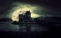 Haunted mystic eerie Eilean Donan Castle in Scotland with the sea around it dark clouds and the moon Royalty Free Stock Photo