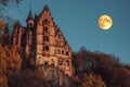 Haunting old mansion illuminated by a ghostly moonlight in a decaying forest at twilight Royalty Free Stock Photo