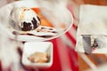 Haute cuisine concept. Ice cream brownie sundae with chocolate sauce and slices of date plum on white plate. Close up. Indoor shot Royalty Free Stock Photo