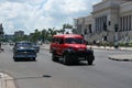 Havana, Cuba - August 25 2018: A van and several classic cars pass by Paseo MartÃÂ­ in front of the Capitol of Cuba.