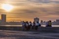 Havana, Cuba - ca. 2021: Skyline in La Habana, Cuba, at sunset, with people sitting on the Malecon. Royalty Free Stock Photo
