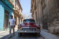 Havana / Cuba - 04.15.2015: Close up shot of a classic vintage red shiny car parked in the streets of Havana as a local man Royalty Free Stock Photo