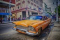 HAVANA, CUBA - 4 DEC, 2015. Orange vintage classic American car, commonly used as private taxi parked in Havana street. Royalty Free Stock Photo