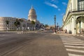 HAVANA, CUBA - DECEMBER 10, 2019: Brightly colored classic American cars serving as taxis pass on the main street in front of the Royalty Free Stock Photo