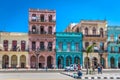 Havana, Cuba - March 11th 2018 - A colorful street full of houses, colonial style, blue sky, tourists taking pictures in Havana, C