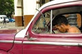 HAVANA, CUBA - MAY 30, 2013 Young Cuban male sitting in old classic american car in Havana,Cuba. Cuba is known for the beauty