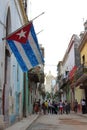 Havana, Cuba - November 20th of 2015: Old Havana's typical street with ruined buildings and a very big cuban flag Royalty Free Stock Photo