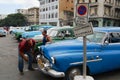 People look to the vintage cars parked at the street in Havana, Cuba. Royalty Free Stock Photo