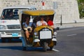 Tourists enjoy trip by the motorbike taxi, known as Coco taxi, at Malecon avenue in Havana, Cuba. Royalty Free Stock Photo