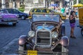 Havana / Cuba - 07/2018: Old and rusty cars of fifties on Havana streets. Brown ones rented on the front view, the pink one on the