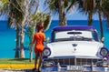 Cuban Latinas posing on the american blue white Ford Fairlane vintage car on the beach in