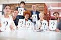 We have the answers to all your questions. Portrait of a group of businesspeople holding up cards with question marks on