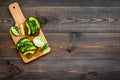 Have a bite with healthy snacks. Avocado toast on dark wooden background top view copy space Royalty Free Stock Photo