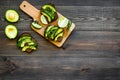 Have a bite with healthy snacks. Avocado toast on dark wooden background top view copy space Royalty Free Stock Photo