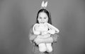 Have blessed Easter. Bunny girl with cute toy on blue background. Child smiling play bunny toy. Happy childhood. Get in