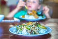 Have a break. Vegetarian food can be delicious for everybody. Boy eat rice and stew vegetables in white plate with Royalty Free Stock Photo