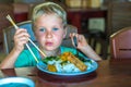 Have a break. Vegetarian food can be delicious for everybody. Boy eat rice and stew vegetables in white plate with Royalty Free Stock Photo