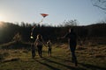 Have fun spending time with two children outdoors in nature. Rear view. Young parents with son and daughter run across field at Royalty Free Stock Photo