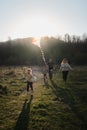 Have fun spending time with two children outdoors in nature. Young Caucasian parents with their son and daughter run across field Royalty Free Stock Photo