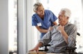 They have a great doctor, patient relationship. a mature female nurse and her senior male wheelchair-bound patient in