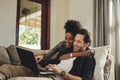 Have a look at that hunny. a happy young couple using a laptop while relaxing on a couch in their living room at home. Royalty Free Stock Photo