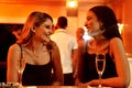 They always have a lot of banter together. two cheerful young women chatting while having drinks inside of a bar at Royalty Free Stock Photo