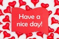 Have a nice day message on red wood sign with red hearts on white fabric Royalty Free Stock Photo