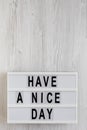 `Have a nice day` words on a modern board on a white wooden background, top view. Overhead, from above, flat lay. Copy space Royalty Free Stock Photo