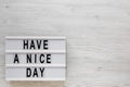 `Have a nice day` words on a modern board on a white wooden background, top view. Overhead, from above, flat lay. Space for text Royalty Free Stock Photo