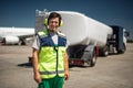 Laughing airport worker with truck on blurred background Royalty Free Stock Photo