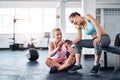 Have you seen these videos of fitness fails. two women looking at something on a cellphone in a gym. Royalty Free Stock Photo