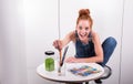 Have young red-haired woman paints picture in her spare time Royalty Free Stock Photo