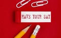 HAVE YOUR SAY message written under torn red paper with pencils and clips, business concept Royalty Free Stock Photo