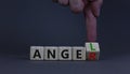 Having anger or being an angel. Businessman turns a wooden cube and changes the word anger to angel. Beautiful grey background. Royalty Free Stock Photo