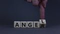 Having anger or being an angel. Businessman turns a wooden cube and changes the word anger to angel. Beautiful grey background. Royalty Free Stock Photo