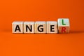 Having anger or being an angel. Turned a wooden cube and changed the word anger to angel. Beautiful orange background. Business Royalty Free Stock Photo