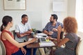 Having a chilled meeting. a group of colleagues working together at a desk in an office.