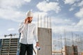 Having conversation by the phone. Man in uniform is working on the construction site Royalty Free Stock Photo