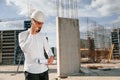 Having conversation by the phone. Man in uniform is working on the construction site Royalty Free Stock Photo