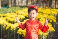 Having fun asian kid at marigold garden. Portrait of funny kid wearing Vietnamese traditional dress Ao Dai at Tet holiday