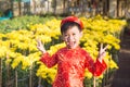 Having fun asian kid at marigold garden. Portrait of funny kid wearing Vietnamese traditional dress Ao Dai at Tet holiday