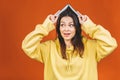 Having fun. Beautiful young woman wearing casual standing isolated over orange background, reading a book Royalty Free Stock Photo