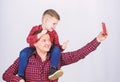 Having fun. Fathers day. Father example of noble human. Father little son red shirts family look outfit. Taking selfie Royalty Free Stock Photo