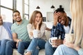 Having fun with friends. Group of young multiracial people drinking coffee at home, joking and laughing together Royalty Free Stock Photo