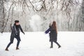 Having fun. Gorgeous young couple playing and throwing snowballs in winter forest Royalty Free Stock Photo