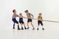 Having fun. Group of little boys, children playing together, pulling the rope over grey studio background. Concept of Royalty Free Stock Photo